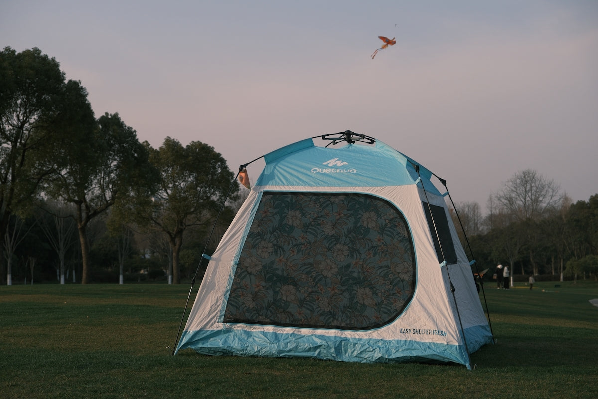 a blue and white tent sitting in the grass