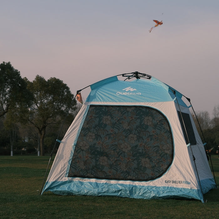 a blue and white tent sitting in the grass