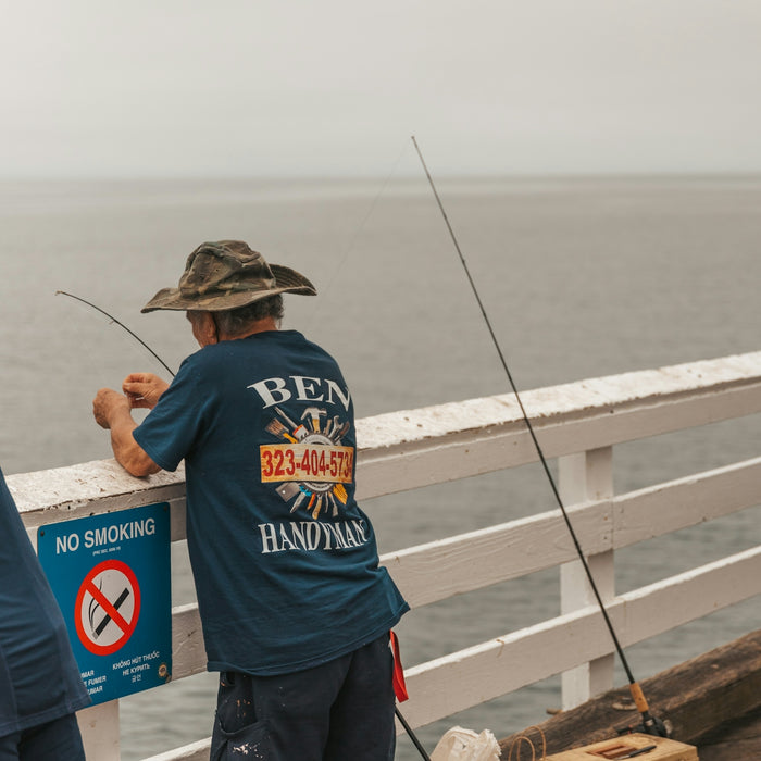 a couple of men standing next to each other on a pier