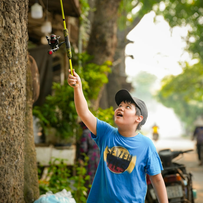 a young boy holding onto a fishing pole