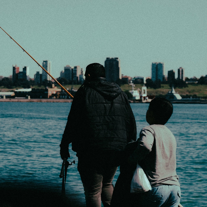 A man and a boy fishing on a lake