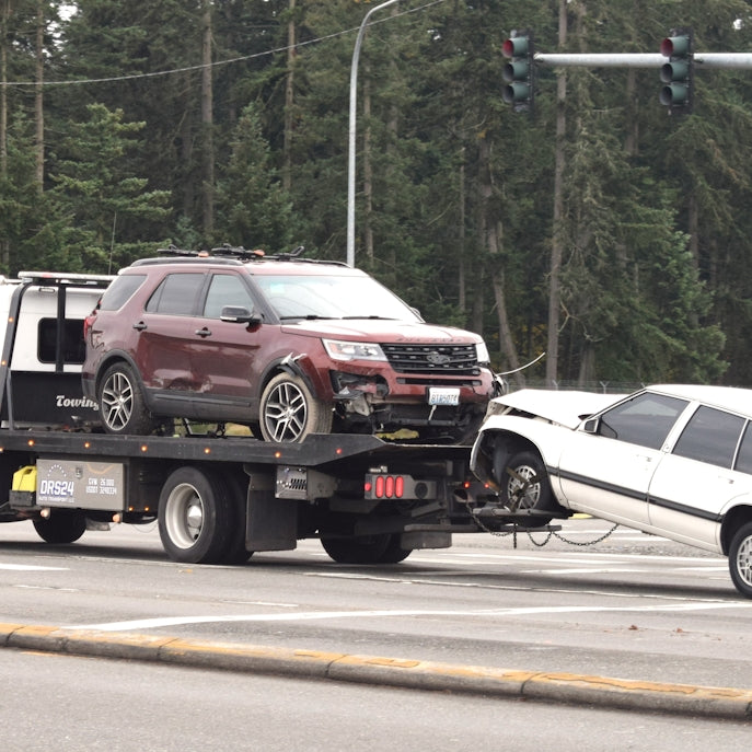 A tow truck towing a car on the road
