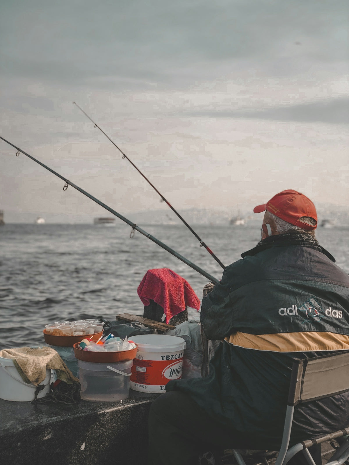 A man sitting on a boat with a fishing rod