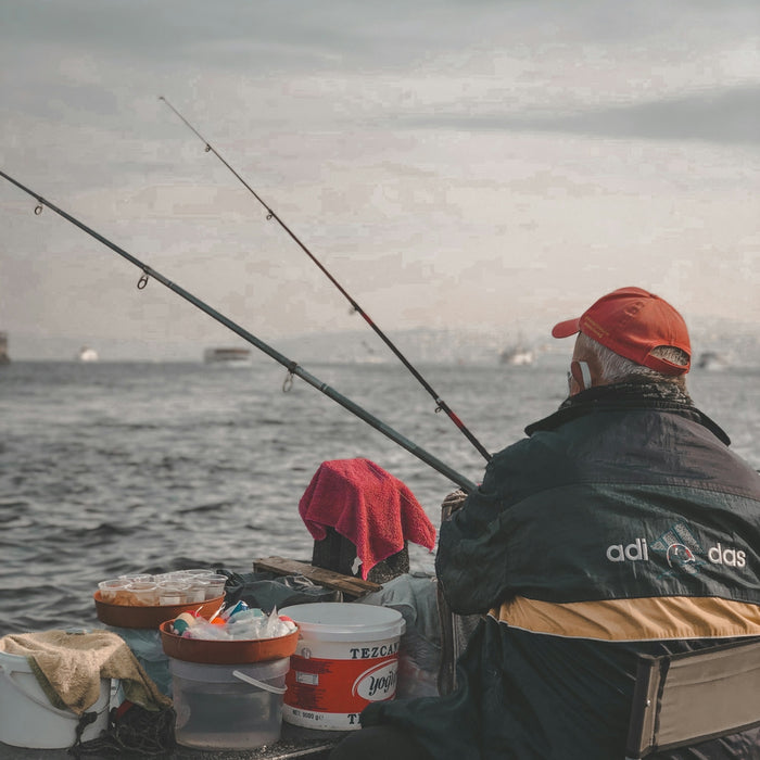 A man sitting on a boat with a fishing rod