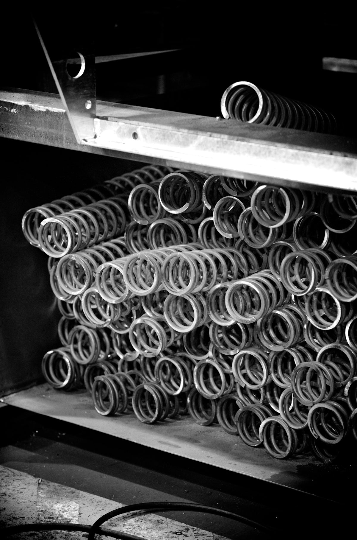 Metal springs are stacked in a warehouse.