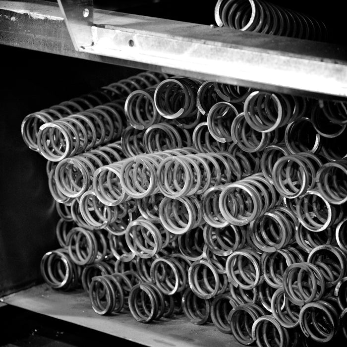 Metal springs are stacked in a warehouse.