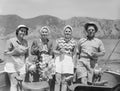 Four people in a boat with hills in background