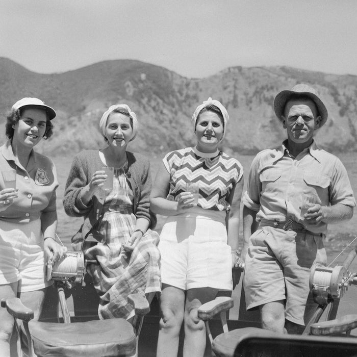 Four people in a boat with hills in background