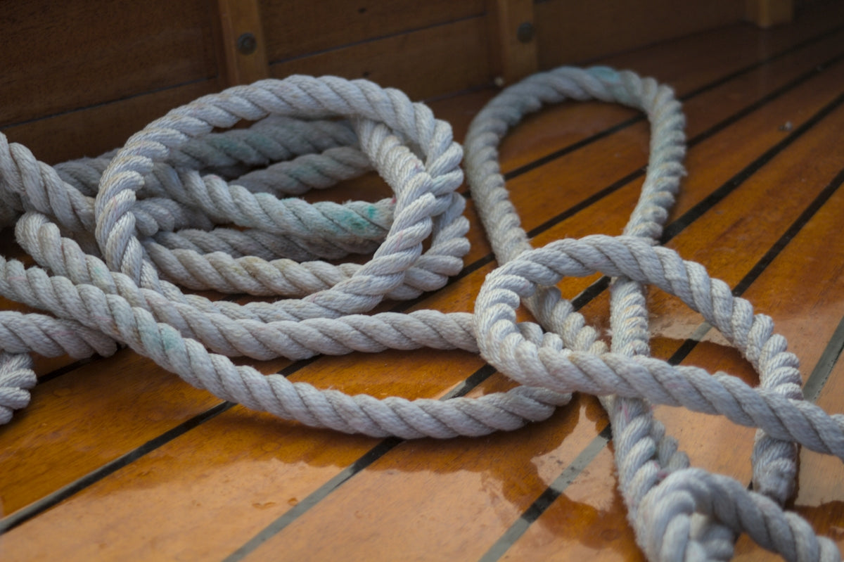 Coiled rope rests on a wooden deck.