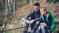 Father and son are fishing together.