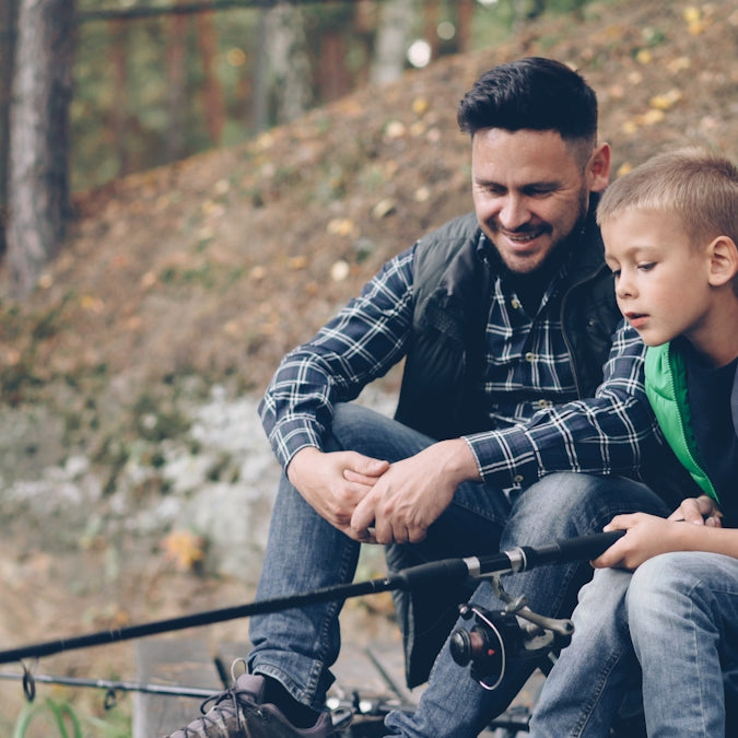 Father and son are fishing together.