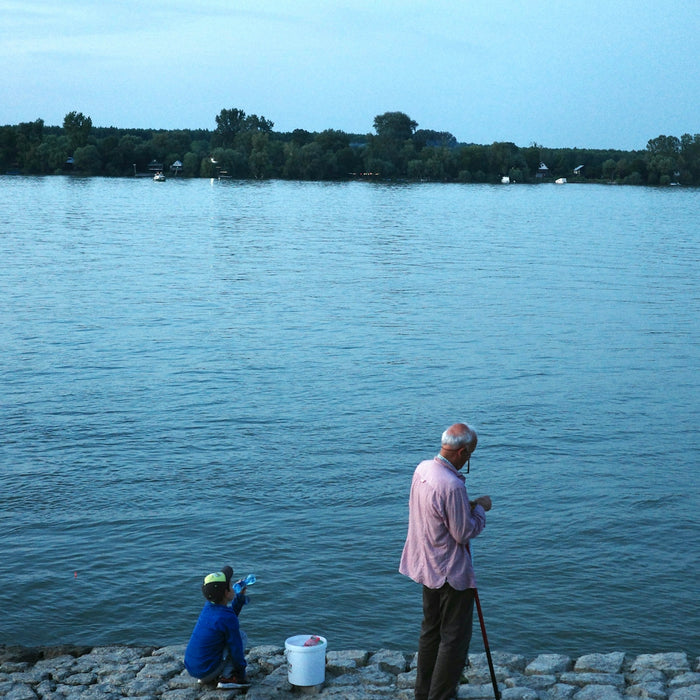 Man and child fishing by the water