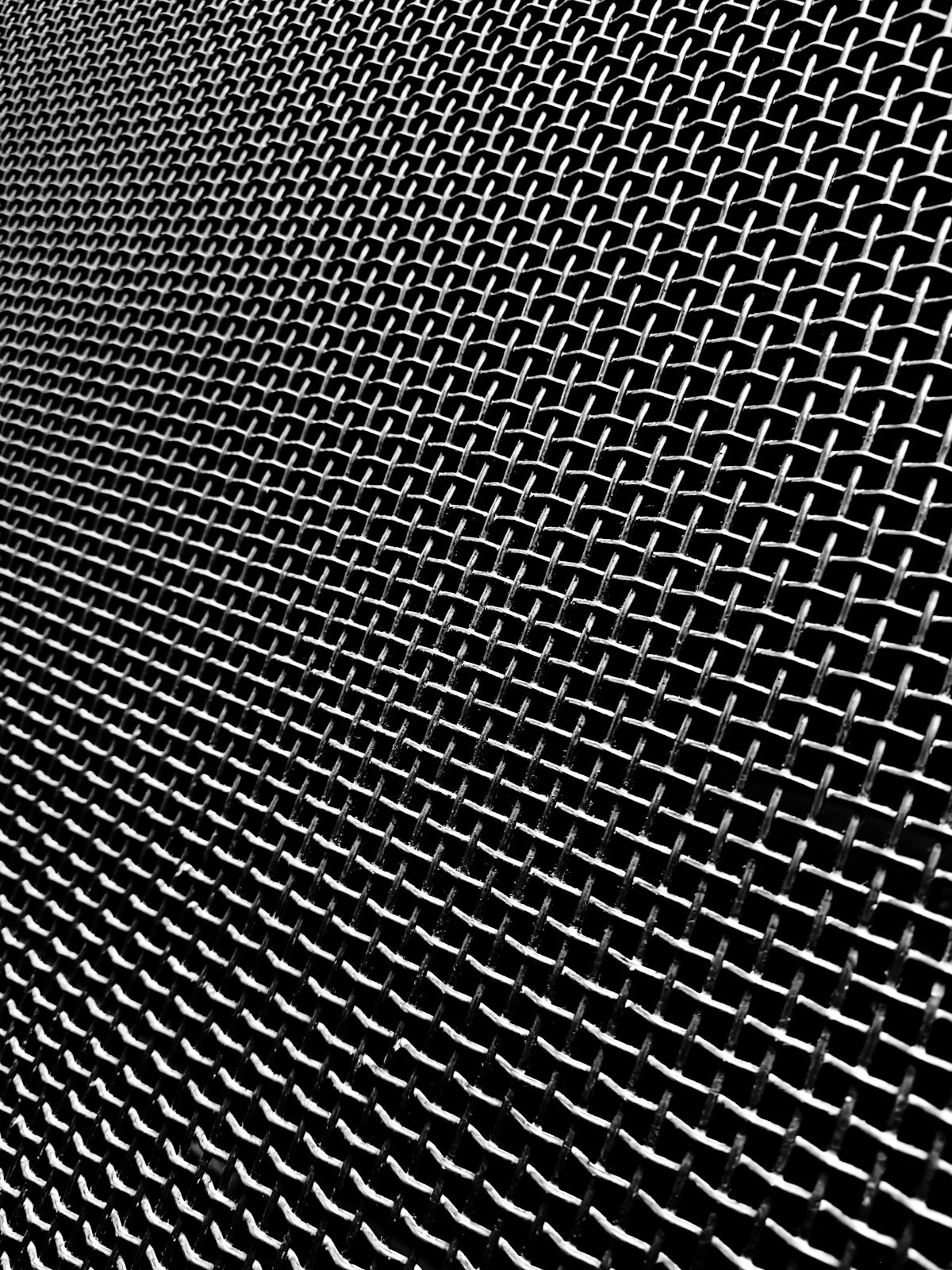 Close-up of a metal mesh screen with a dark background