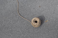 A ball of twine on a gray surface
