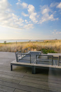 Modern outdoor seating area overlooking a tranquil bay.