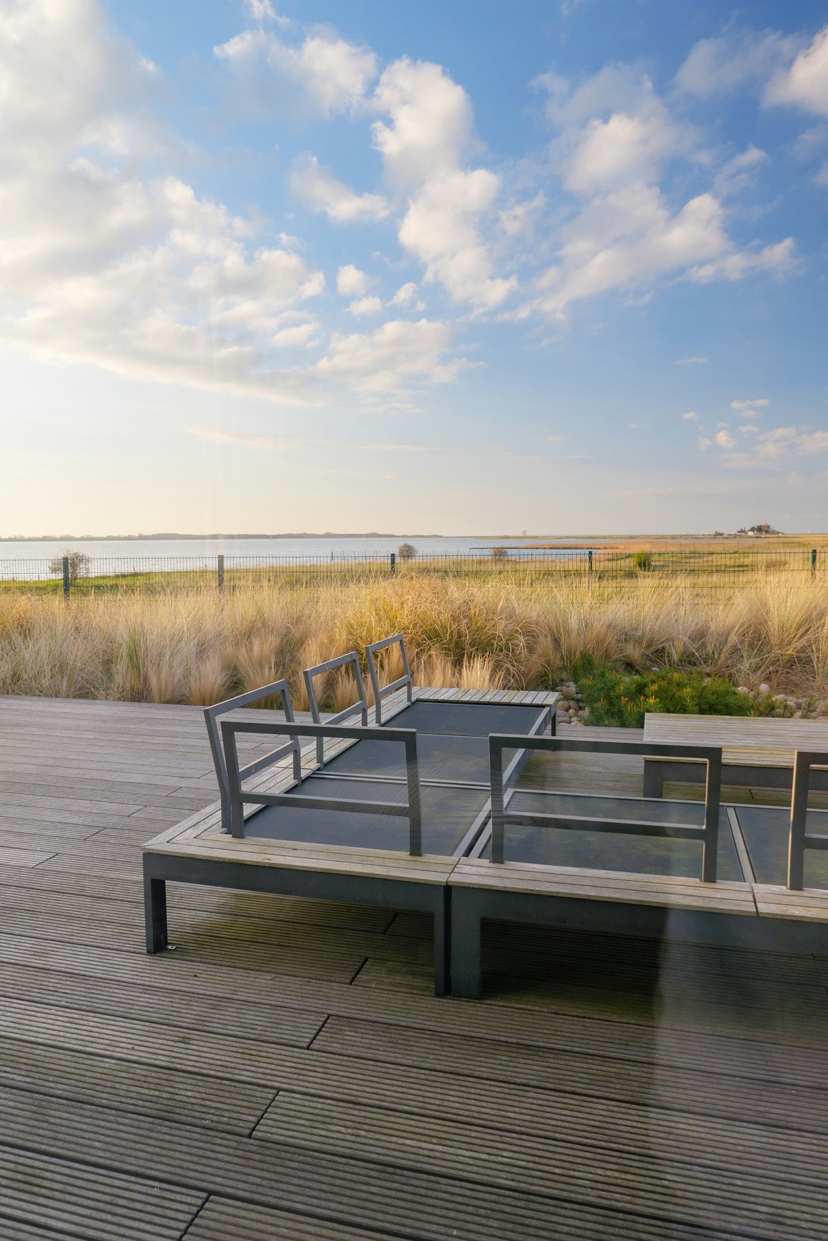 Modern outdoor seating area overlooking a tranquil bay.