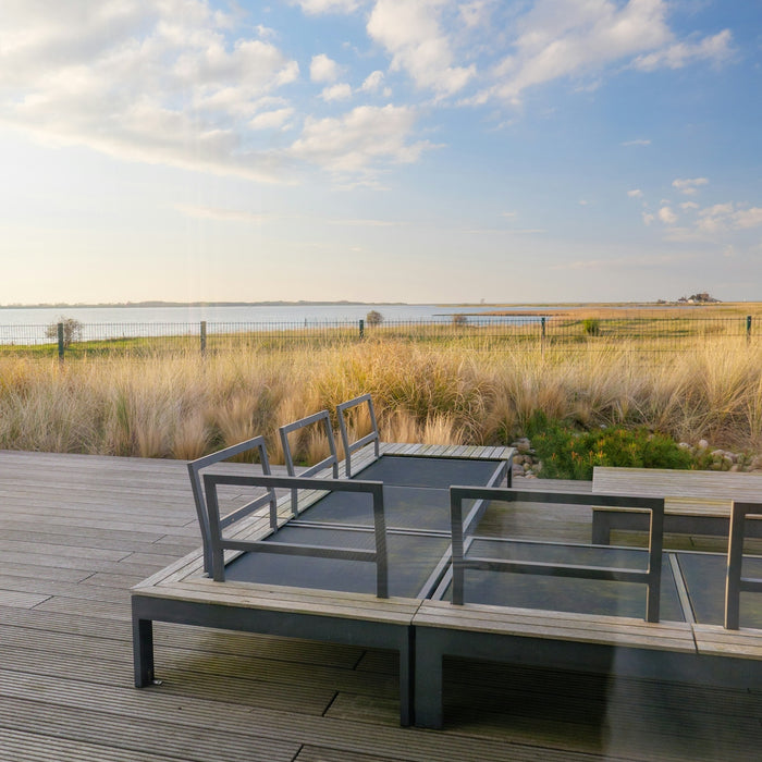 Modern outdoor seating area overlooking a tranquil bay.