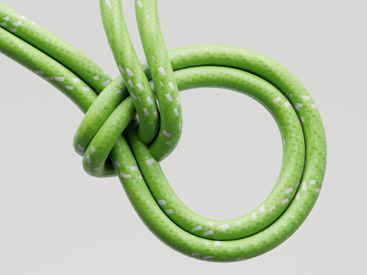 Green cord tied in a knot against white background