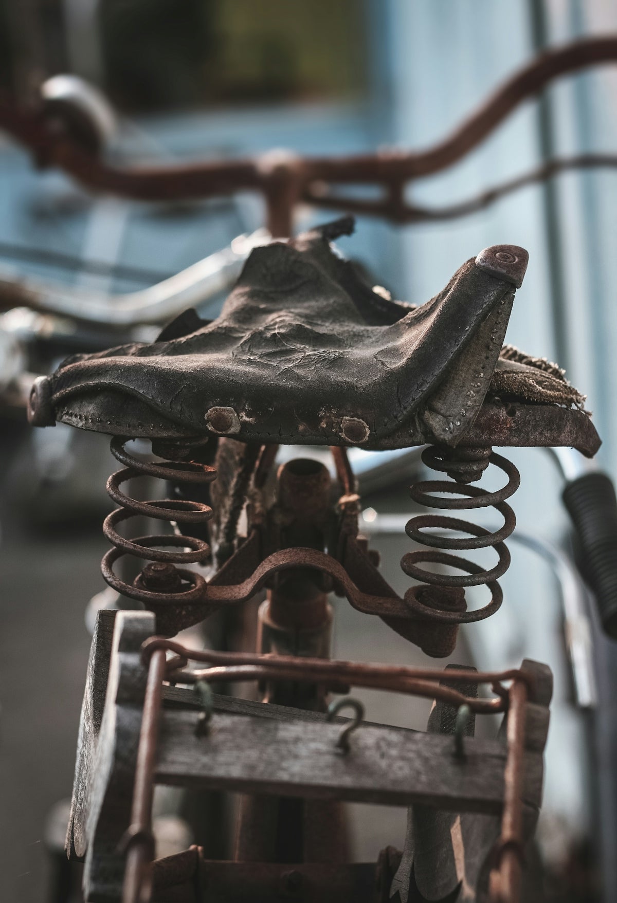 Close-up of a rusty vintage bicycle seat with springs.