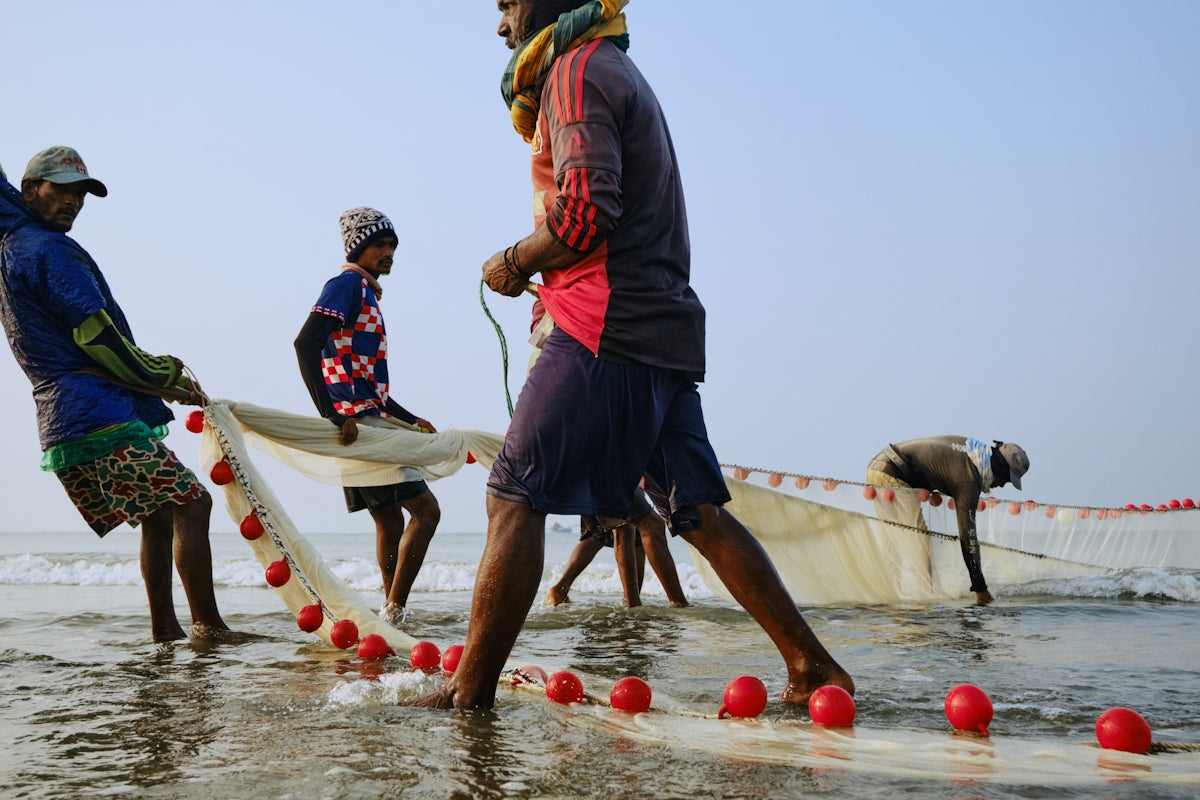 Fishermen pulling a large net from the ocean