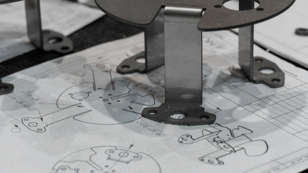 Metal components resting on engineering blueprints