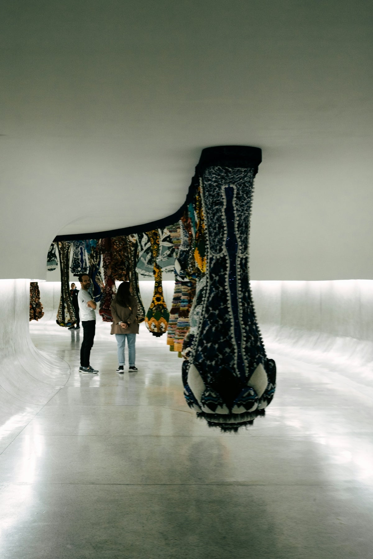 People observe hanging textile art installation