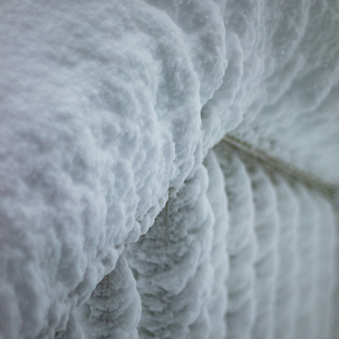 Thick ice formations on a railing in winter
