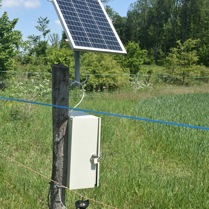 A solar panel powers an electric fence in a field