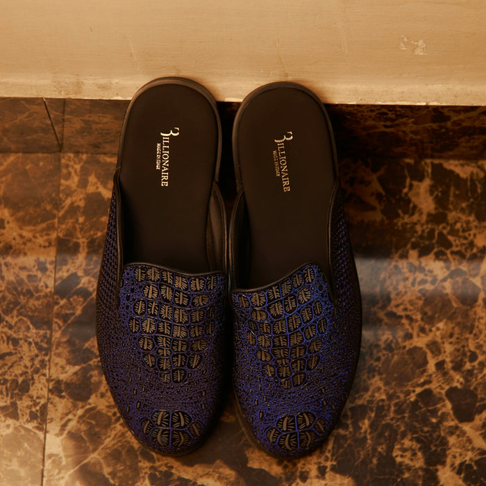 Dark blue crocodile-textured slippers on a polished marble floor