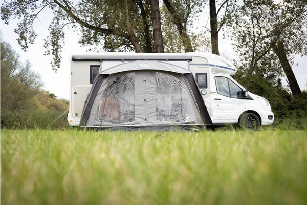 Vango Sunlight Air 380 Elements Proshield awning canopy setup next to a campervan in a grassy outdoor setting.