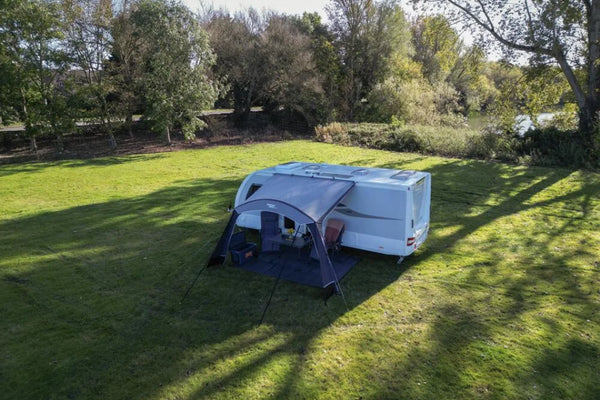 Vango Sunlight Air 380 Elements Proshield awning canopy setup next to a campervan in a green outdoor space.