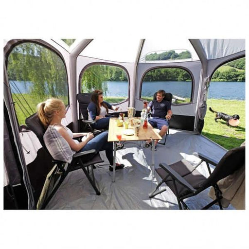 Vango Airhub Hexaway II Low 2.5M Awning providing a spacious area for socializing by a lake.