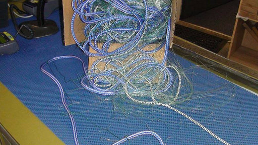 South Island flounder set nets tangled blue and green fishing line on a work surface.
