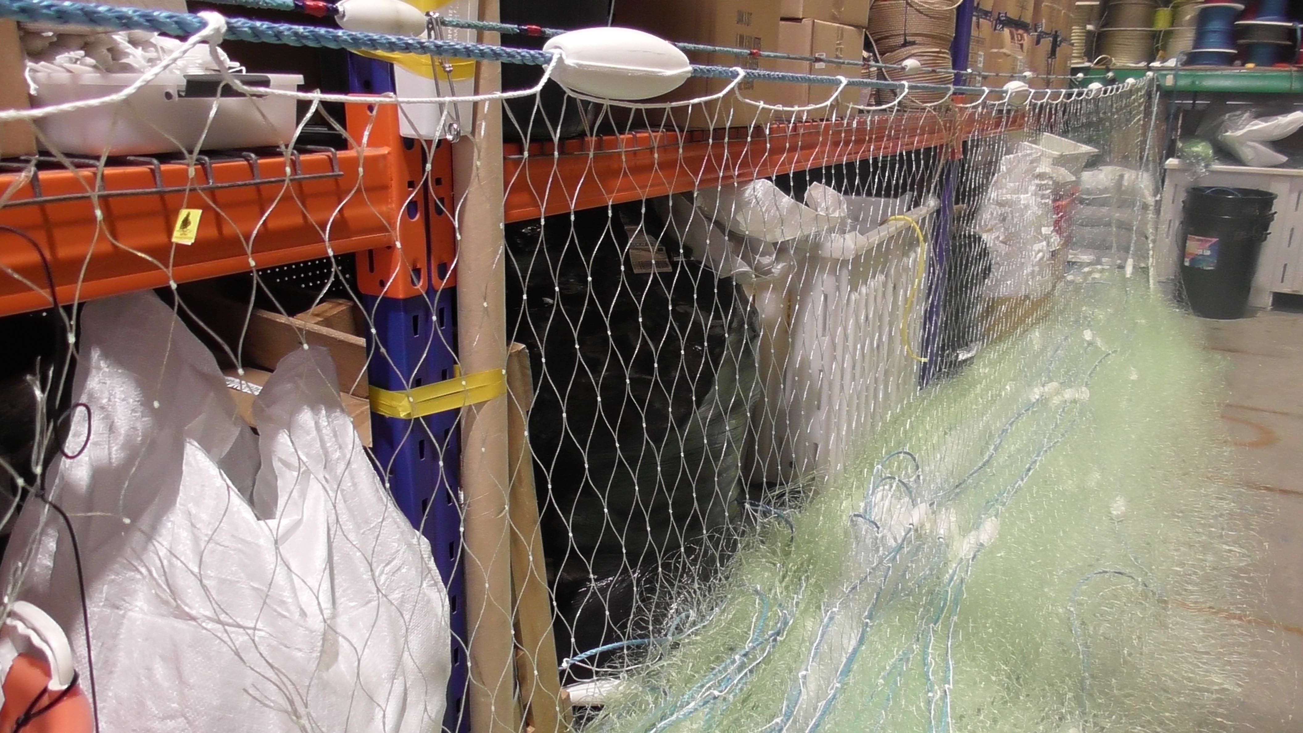 500m Commercial Mullet Fishing net displayed on shelves with various fishing supplies and storage.