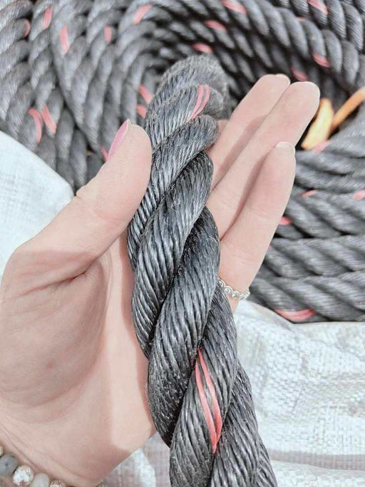 32mm SuperTec Black Rope 4 Strand Sold by the Meter held in hand, showcasing heavy-duty construction and durability.