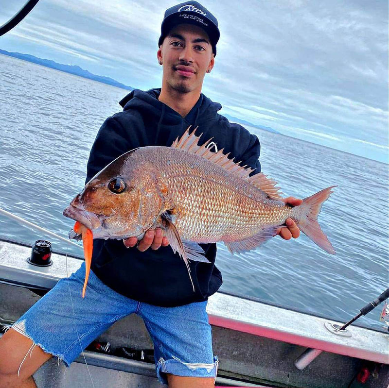 Person holding a large fish while fishing on a boat, showcasing a successful catch.