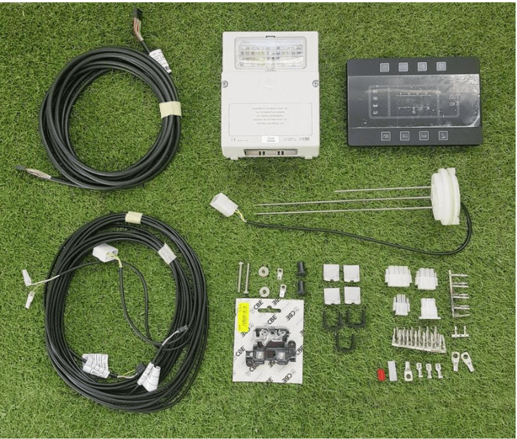 Multi Control Panel Kit PC180 components including control panel, cables, connectors, and accessories on green grass.