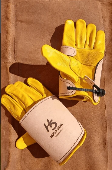 Hugo Silva Heavy Tackle Gloves Large to XX Large on a leather background, showcasing protective yellow leather design.