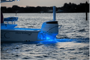 Seablaze Mini Led Underwater Light - Spectrum illuminating water behind a boat at sunset.