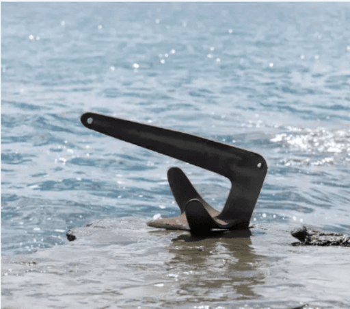 Galvanised Ray Anchor 10kg to 80kg on a rocky shore with water in the background.
