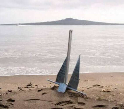 Mason Galvanised Sand Anchors 5Kg - 44Kgs anchored in sand by the shore with water in the background.