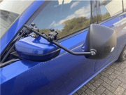 Milenco Platinum Grand Aero Mirrors attached to a blue car, showcasing the innovative design for improved aerodynamics.
