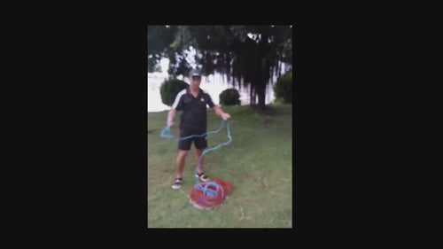 Frisbee Style 6FT x 1-00 Inch AM Style Cast Net demonstration by angler in grassy area.