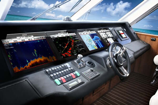 Boat dashboard with multiple screens and controls on a sunny day.