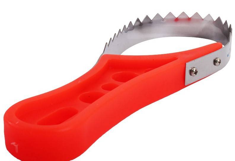 Sea Harvester Stainless Steel Fish Scaler with ergonomic red handle and metal spikes for easy fish scaling.