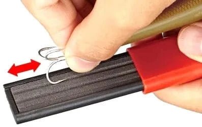 Hand sharpening a fishing hook with the Sea Harvester Hook Hone, featuring a fine grit for performance restoration.