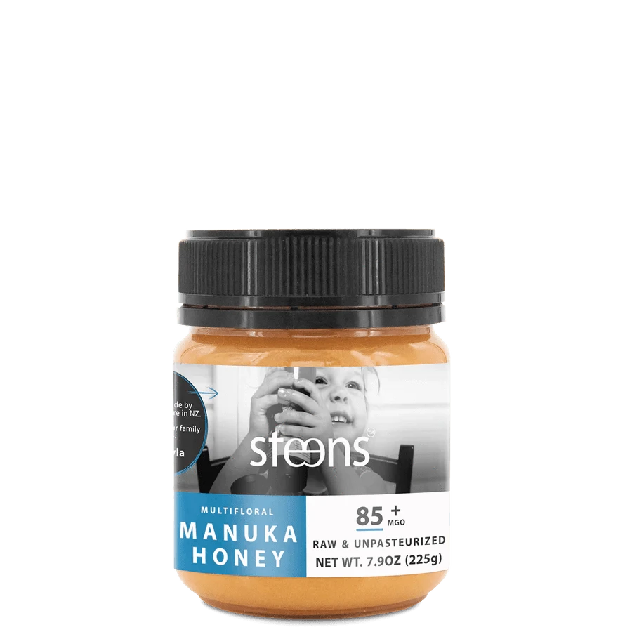 MGO 85 Raw Multifloral Mānuka Honey 225g jar, featuring a child holding the honey, in a sleek design.