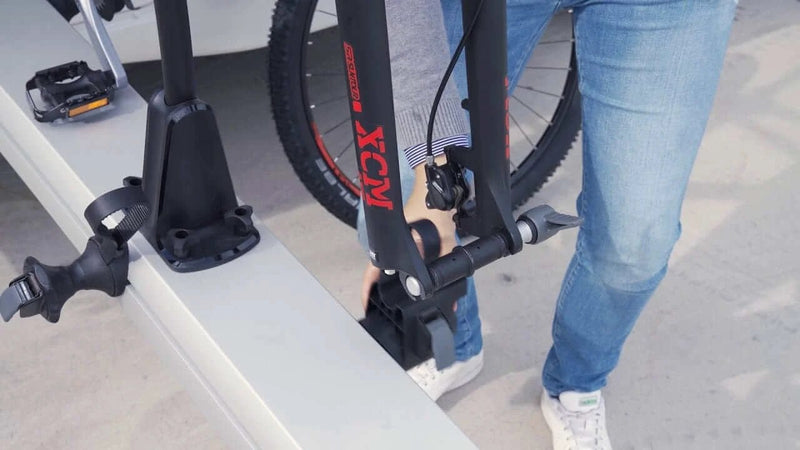 Thule VeloSlide Fork Mount Adapter - Thru Axle being installed on a bike in a garage setting.