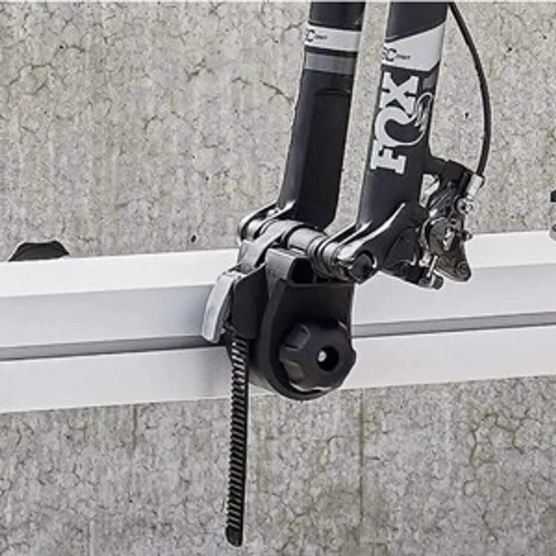 Thule VeloSlide Fork Mount Adapter - Thru Axle attached to a bike fork in a garage setting.