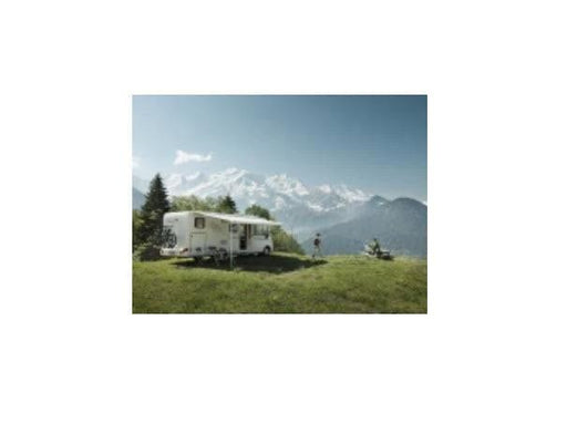 8000 Thule Wall Awning Grey 6.0m providing shade for outdoor living near mountains.